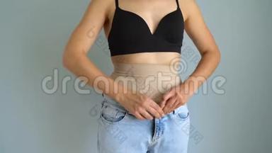 穿着紧身内裤的女人把牛仔裤放在上面，检查结果。 追求完美身材的理念